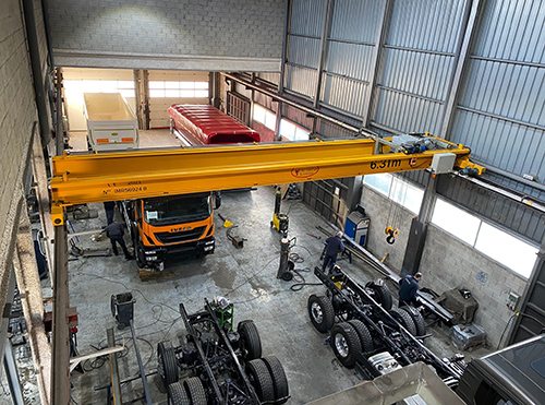 Interior del taller Cargoequip con puente grúa y camiones